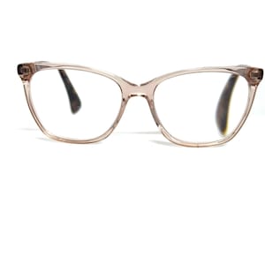 May include: A pair of vintage cat-eye eyeglasses with a light brown frame. The lenses are clear, and the frame has a subtle, translucent quality. The glasses have a classic, retro design.