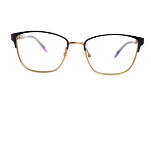 May include: Eyeglasses with a black upper frame and gold-colored lower frame. The lenses are clear, and the nose bridge is gold. The glasses have a modern, stylish design.