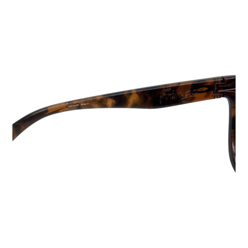 May include: Close-up of the tortoiseshell frame of a pair of sunglasses. The sunglasses have the word "Fringe" printed on the frame.