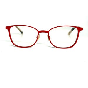 May include: A pair of eyeglasses with a bright red frame and clear lenses. The frame features a rounded rectangular shape with thin, metallic-toned nose pads and temple arms that transition into a patterned, multi-colored tortoiseshell design.