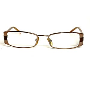 May include: Rectangular eyeglasses featuring a metallic bronze frame with dark brown accents on the outer edges. The glasses have clear lenses, a thin bridge, and adjustable nose pads, providing a structured look with a polished finish.