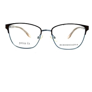May include: Petite fit eyeglasses with a dark brown frame and a light blue lower rim. The glasses have a delicate, modern design with the brand name BCBGMAXAZRIA printed on the right side.