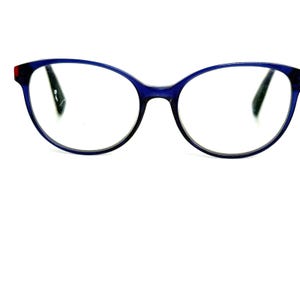 May include: Eyeglasses with a dark blue frame and clear lenses. The frame has a rounded cat-eye shape with a small red accent on the left side. The glasses are set against a white background.