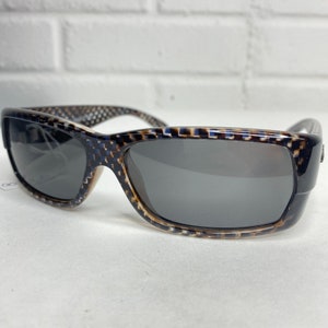 May include: A pair of black and brown sunglasses with a checkered pattern on the frame. The lenses are dark gray.