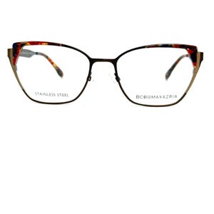 May include: Cat-eye eyeglasses with a dark brown metal frame. The upper rims feature a colorful pattern of red, yellow, and blue. The text "STAINLESS STEEL" and "BCBGMAXAZRIA" are printed on the frame.