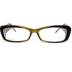 May include: Rectangular spectacles featuring a gradient frame that transitions from a deep purple at the outer edges to a translucent olive green toward the centre bridge. The clear lenses are framed by a smooth, polished plastic material.