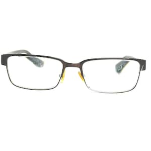 May include: Rectangular eyeglasses with a dark brown frame and clear lenses. The glasses have a classic design with a thin frame and a bridge. The lenses are clean and the glasses appear to be in good condition.