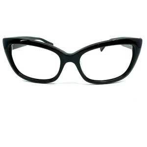 May include: Black cat-eye glasses with a thick frame and clear lenses.