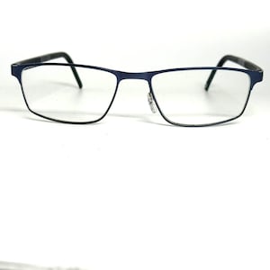 May include: A pair of rectangular eyeglasses featuring a thin, matte navy blue metal frame. The glasses have clear lenses, a straight bridge, and slender temples that curve slightly at the ends. The design is simple, functional, and lightweight.
