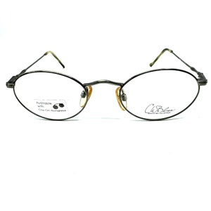 Può includere: Occhiali ovali argentati con logo C. Bliss Signature Collection sulla lente destra. La lente sinistra ha un adesivo che dice "Disponibile con occhiali a clip".