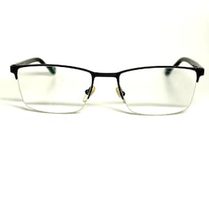 May include: Semi-rimless eyeglasses featuring a thin matte black metal frame across the top of the lenses. The design includes adjustable nose pads and slender black temples that curve at the ends. The rectangular lenses are clear and unobstructed.