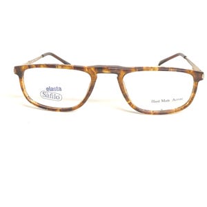 Può includere: Occhiali con montatura a fantasia tartarugata e sottili aste in metallo. L'area della lente sinistra presenta il testo "elasta Safilo". L'area della lente destra presenta il testo "Hand Made Acetate".