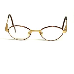 Peut inclure: Lunettes de forme ovale dotées d'une fine monture en métal doré avec un motif écaille de tortue marron sur les bords. Les branches sont marron foncé et le pont est une simple barre en métal doré reliant les deux verres ovales.