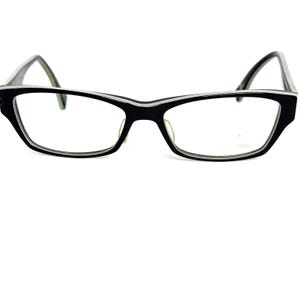 May include: Black rectangular eyeglasses with a thin white stripe along the rim.