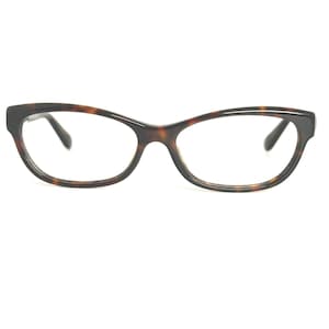 May include: A pair of eyeglasses with a tortoiseshell pattern frame. The frames have a cat-eye shape, with a dark brown and black color scheme. The lenses are clear, and the glasses are set against a white background.