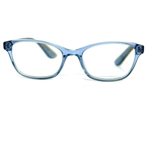 May include: Light blue eyeglasses with a cat-eye shape. The frames are a translucent, pale blue color, and the lenses are clear. The temples are a darker gray color. The glasses are set against a white background.