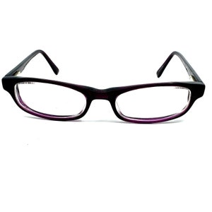 May include: Purple plastic framed eyeglasses with clear lenses.