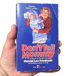 May include: A paperback book cover with a blue background and a woman holding a baby in a blue blanket. The title of the book is "Don't Tell Mommy" and the author is Harold Lee Friedman. The book is a novel of terrible secrets.