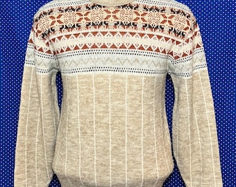 May include: A beige sweater with a brown, white, and black geometric pattern on the top half. The bottom half of the sweater is a solid beige with vertical stripes.