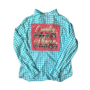 May include: A turquoise and white gingham button-up shirt with a red patch on the back that says "Country Born Heaven Bound" in a stylized font.