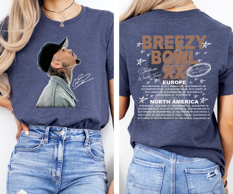 May include: Navy blue t-shirt featuring a portrait of a man wearing a black cap and denim jacket. The back of the shirt displays the text "Breezy Bowl XX Stadium World Tour" with a list of European and North American tour dates.