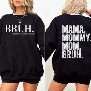 May include: Black sweatshirt with white text on the front that says "BRUH. -FORMERLY KNOWN AS MOM" and white text on the back that says "MAMA. MOMMY. MOM. BRUH."