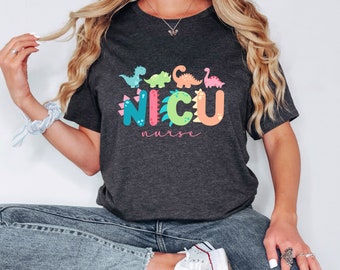 May include: A dark gray t-shirt with a colorful dinosaur graphic that says "NICU nurse".