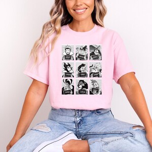 Puede incluir: Una camiseta rosa claro con una cuadr&iacute;cula de nueve ilustraciones en blanco y negro de villanos de dibujos animados al estilo de una foto policial. Cada imagen tiene un a&ntilde;o impreso debajo. La camiseta la lleva una persona.