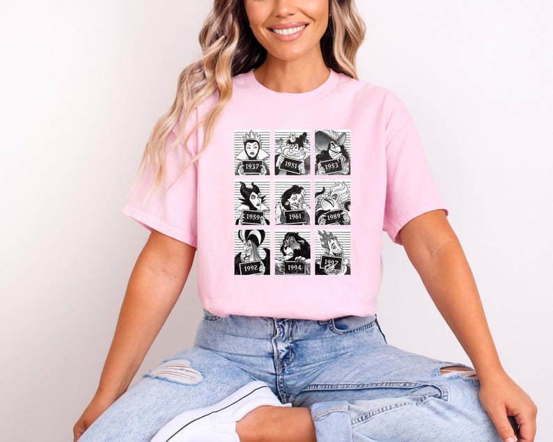 Puede incluir: Una camiseta rosa claro con una cuadr&iacute;cula de nueve ilustraciones en blanco y negro de villanos de dibujos animados al estilo de una foto policial. Cada imagen tiene un a&ntilde;o impreso debajo. La camiseta la lleva una persona.
