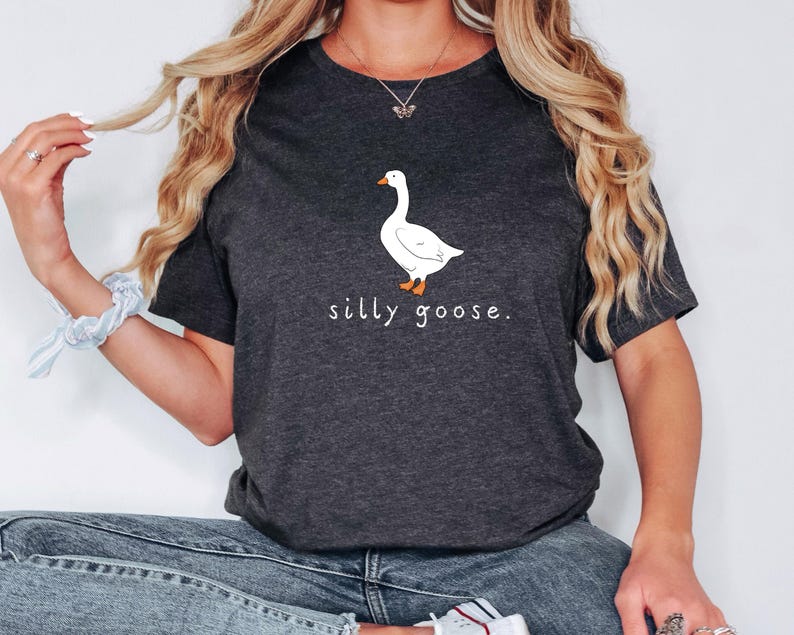 K&ouml;nnte beinhalten: Ein dunkel-melierter grauer T-Shirt mit einer wei&szlig;en G&auml;nse-Illustration und dem Text "silly goose."