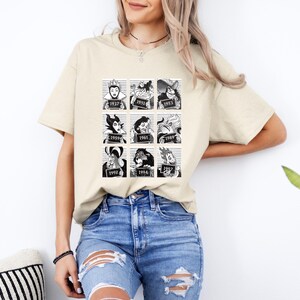 Puede incluir: Camiseta beige con un gr&aacute;fico en blanco y negro de villanos de Disney en cajas estilo ficha policial, cada una con un a&ntilde;o. La camiseta la lleva una persona con cabello claro y vaqueros azules.