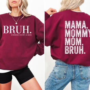 May include: Burgundy sweatshirt with white text on the front that reads "BRUH. -FORMERLY KNOWN AS MOM" and white text on the back that reads "MAMA. MOMMY. MOM. BRUH."