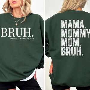 May include: A dark green sweatshirt with the text "BRUH. -FORMERLY KNOWN AS MOM" on the front and "MAMA. MOMMY. MOM. BRUH." on the back.