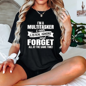 Puede incluir: Una camiseta negra con texto blanco que dice "Soy un multitarea, puedo escuchar, ignorar y olvidar todo al mismo tiempo!"