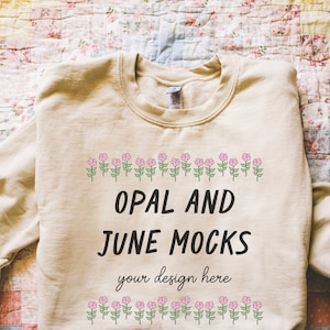 Sand Sweatshirt Mockup: Photograph of Folded Sand Gildan 18000 Crewneck on Quilt | Cute Boho Cottagecore Style Flatlay of Beige Sweatshirt