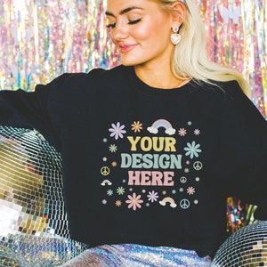 Puede incluir: Sudadera negra con un diseño gráfico colorido que dice "YOUR DESIGN HERE" rodeado de flores, arcoíris y signos de paz.