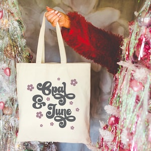 Mockup di borsa tote: foto colorata di una modella che tiene in mano una borsa tote Liberty OAD113 / Mockup carino per le feste con glitter di borsa tote, Capodanno o Natale