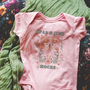 Pink Baby Bodysuit Mockup: Photo of Rabbit Skins 4424 Infant Fine Jersey Bodysuit | Cute Flatlay Mockup, Dark Cottagecore and Bookish Vibes