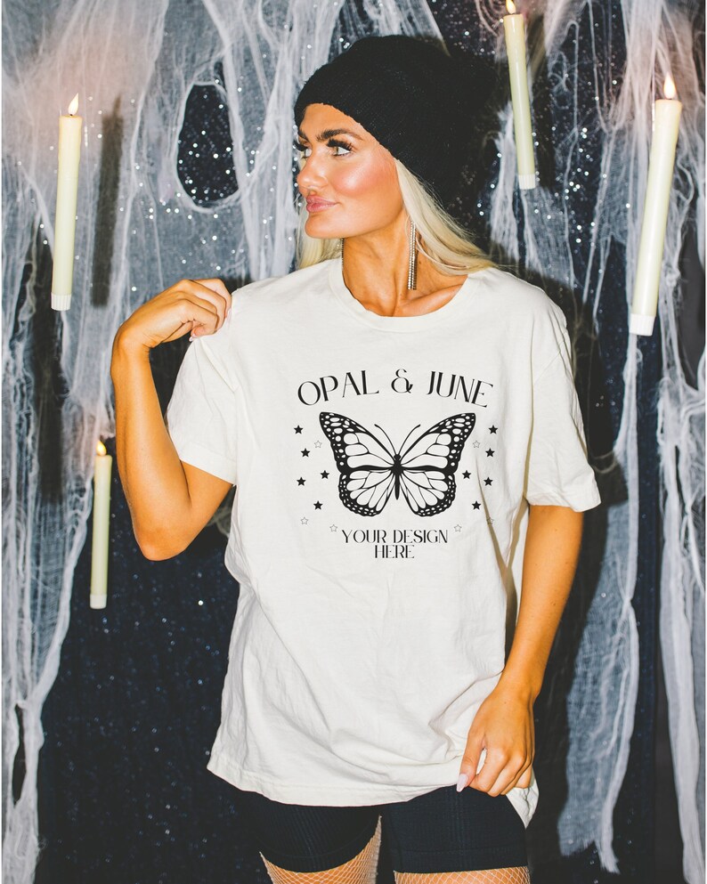 Pode incluir: Uma camiseta branca com um gr&aacute;fico de borboleta preta e o texto "OPAL & JUNE" e "YOUR DESIGN HERE".
