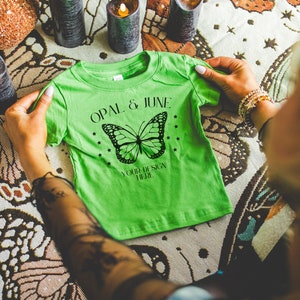 Apple T-Shirt Mockup: Foto colorata del modello che piega le bucce di coniglio Apple 3322 Infant Fine Jersey Tee / Mockup Whimsigoth accogliente per Halloween