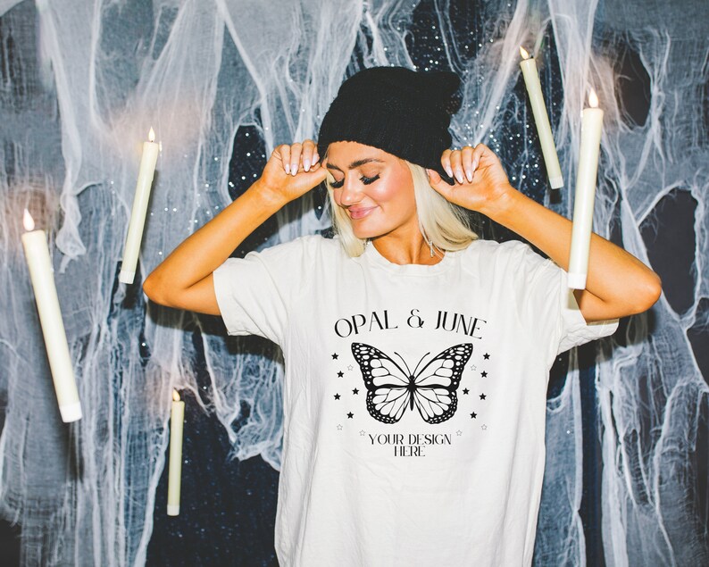 May include: A white t-shirt with a black butterfly graphic and the text "Opal & June" and "Your Design Here".