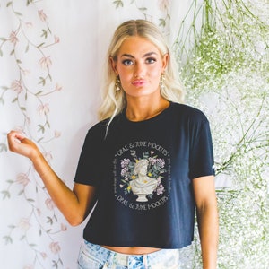 Może przedstawiać: Czarny, kr&oacute;tki T-shirt z białym wzorem kwiatowym i nadrukiem "OPAL & JUNE MOCKUPS" z przodu.