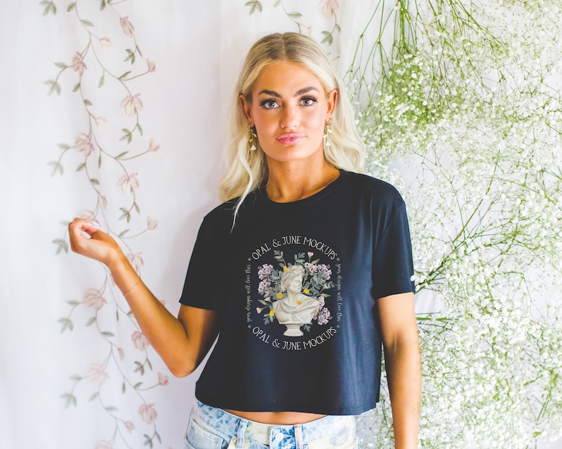 Może przedstawiać: Czarny, kr&oacute;tki T-shirt z białym wzorem kwiatowym i nadrukiem "OPAL & JUNE MOCKUPS" z przodu.