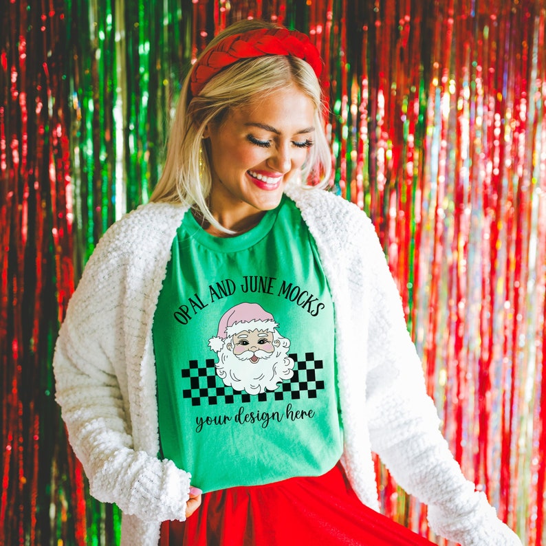 May include: A green t-shirt with a chequered pattern and a cartoon Santa Claus graphic. The text "OPAL AND JUNE MOCKS" is printed above the graphic and "your design here" is printed below the graphic.
