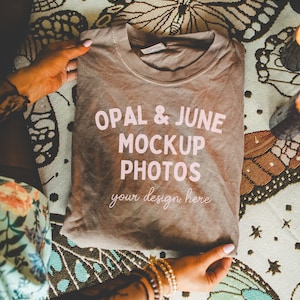 May include: A brown t-shirt with the text "OPAL & JUNE MOCKUP PHOTOS your design here" printed in pink on the front.