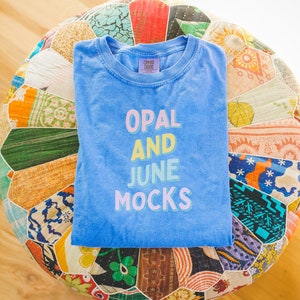 Mockup of Periwinkle Comfort Colors® Tee Shirt: Folded Blue Tee on Boho Patterned Cushion | Photo of Periwinkle C1717 T-Shirt, Spring Mockup