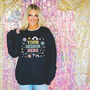 May include: Black sweatshirt with a colorful graphic design featuring flowers, rainbows, and peace signs. The text "YOUR DESIGN HERE" is printed on the front of the sweatshirt.
