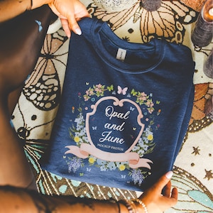 May include: A navy blue sweatshirt with a floral design and the text "Opal and June Mockup Photos" in a white frame.