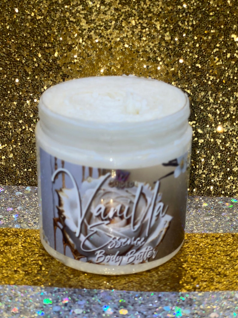 May include: A white jar of Vanilla Essence Body Butter with a white rose and gold accents on the label.