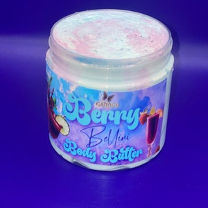 May include: A white jar of whipped body butter with a pink and blue swirl on top. The jar has a label that says "Gourmet Berry Bellini Body Butter".